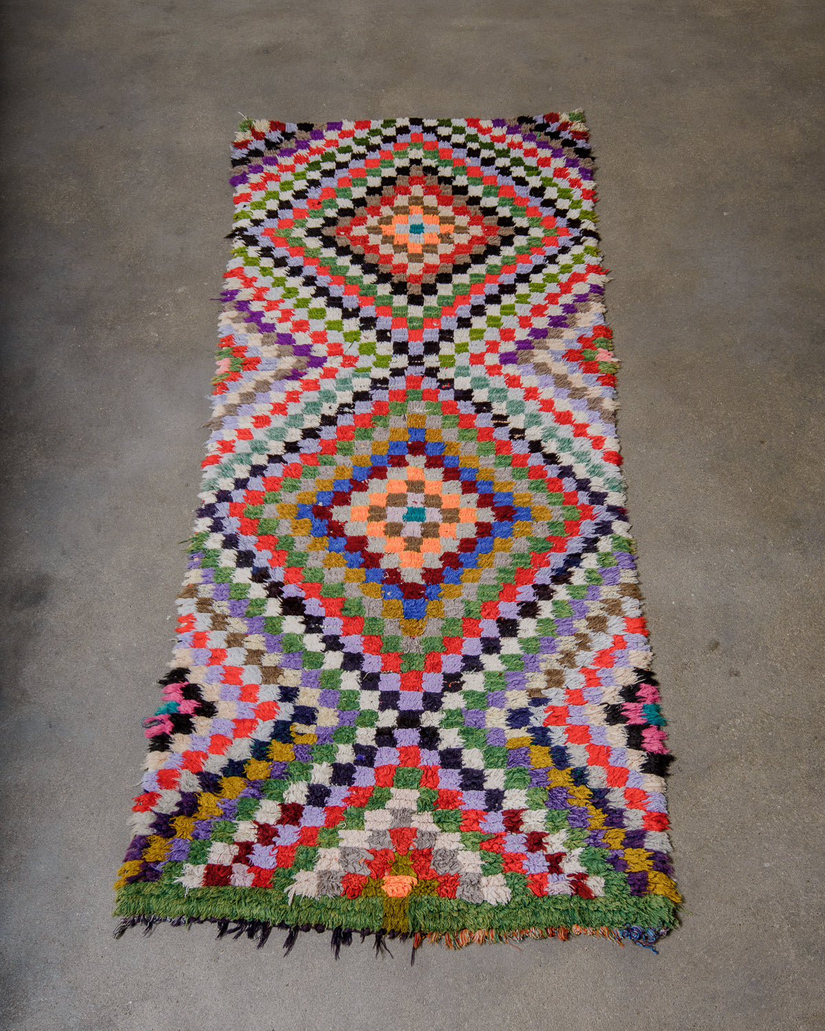 Multicoloured geometric patterned rug on a concrete floor